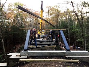 A large crane lifts a steel truss into place on the Jaquith Rail Trail bridge. (photo © Jeremy Wilson)