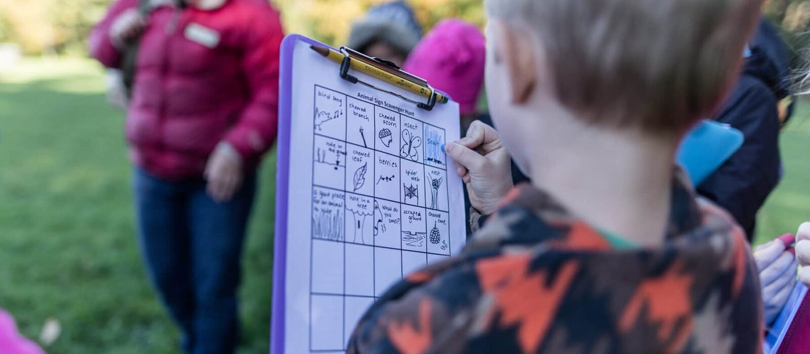 A 2nd grader embarks on an animal sign scavenger hunt in an outdoor learning area near his school. (photo © Ben Conant)