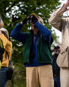 A photo of Meade Cadot peering through bincoluars. (photo © Ben Conant)