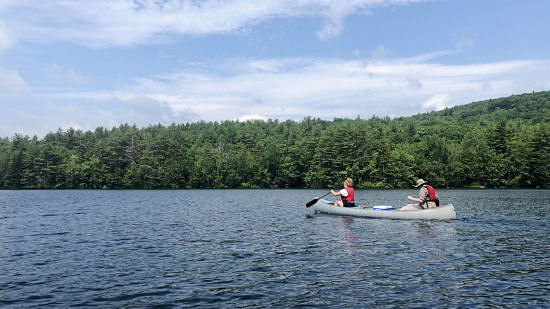 Two people paddle a canoe on Spoonwood Pond. (photo © Brett Amy Thelen)