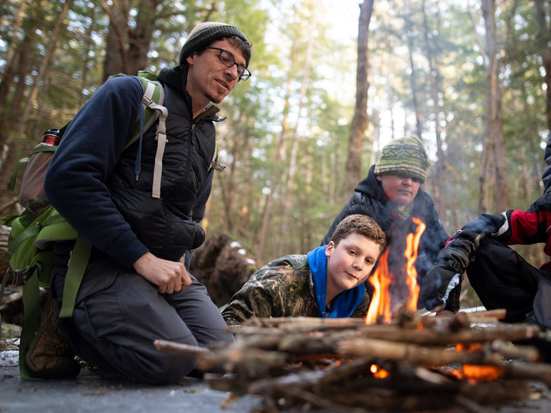 John Benjamin and campers gather around a fire they have just built. (photo © Ben Conant)