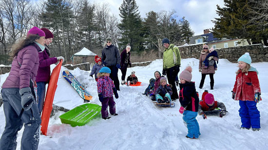 Babies, toddlers, & adults bundled up to sled in the snow (photo © Martha Duffy)