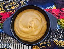 A full pot of butternut squash soup against a colorful tablecloth. (photo © Lisa Murray)