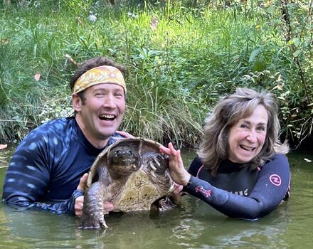 Sy Montgomery and Matt Patterson in the pond with Fire Chief (photo © Susie Spikol)