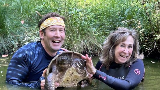 Sy Montgomery and Matt Patterson in the pond with Fire Chief (photo © Susie Spikol)