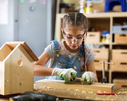 A girl building a bird house (photo © Adobe)