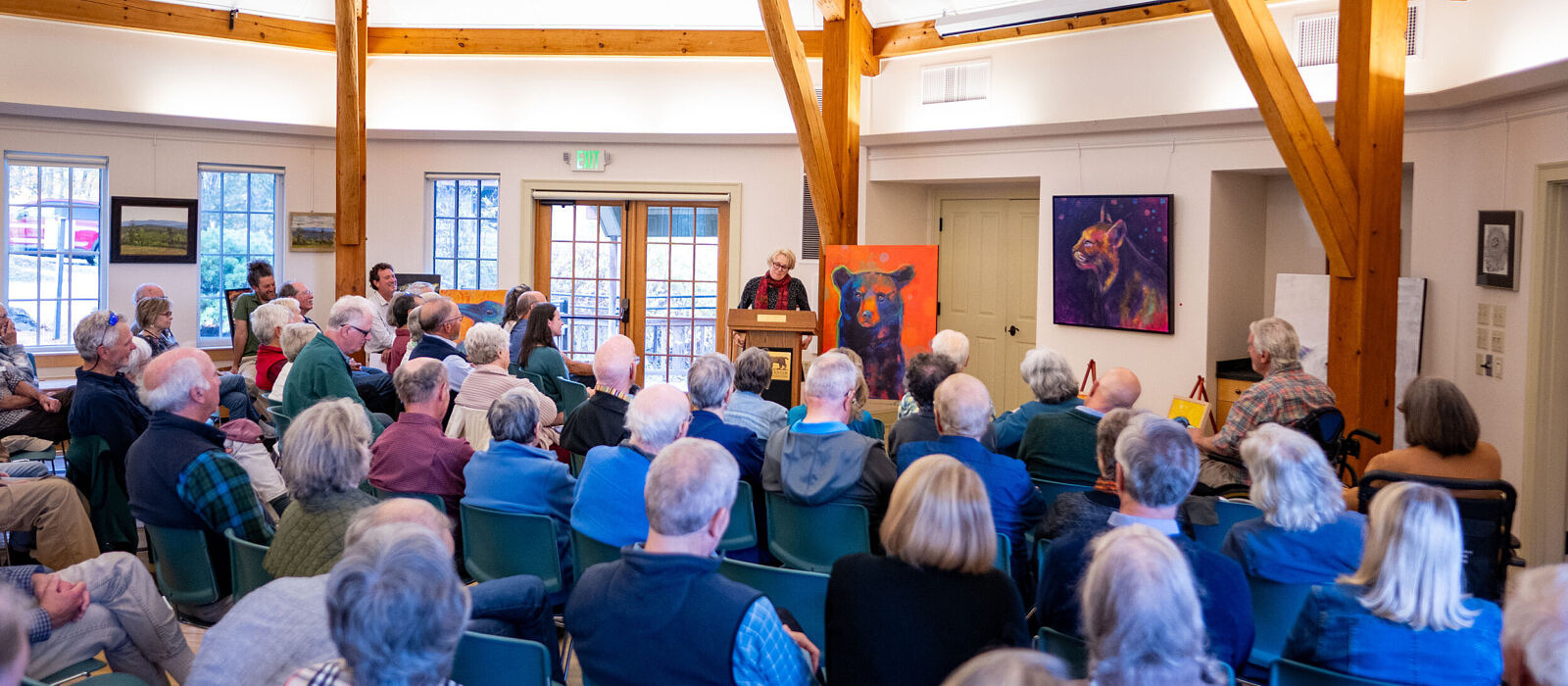 Artist Rosemary Conroy speaking at the 2025 Annual Meeting alongside some of her artwork (photo © Ben Conant)