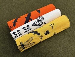 A cream-colored bandana with black silhouettes of plants and animals.