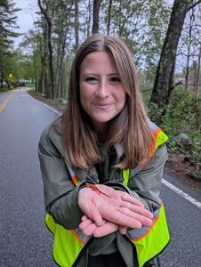 Intern Lena Goins holding a red eft.