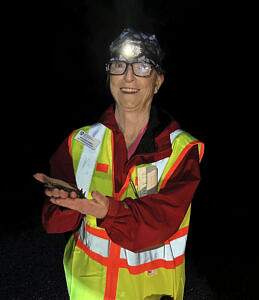 Salamander Brigade volunteer Meg Deschenes wearing a reflective vest and holding a spotted salamander. (photo © Sarah Thomas)