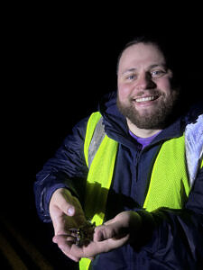 A Salamander Brigade volunteer smiles while holding a spotted salamander. (photo © Emily Houston)