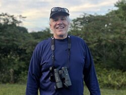 Michael Rafferty smiling with binoculars around his neck.